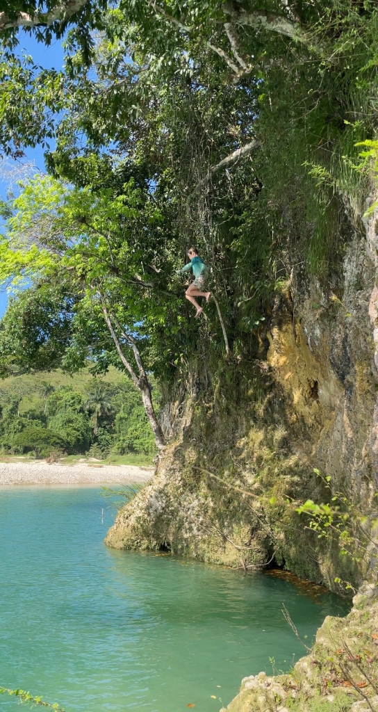 Child climbing a tree by the river at Blossom Forest School